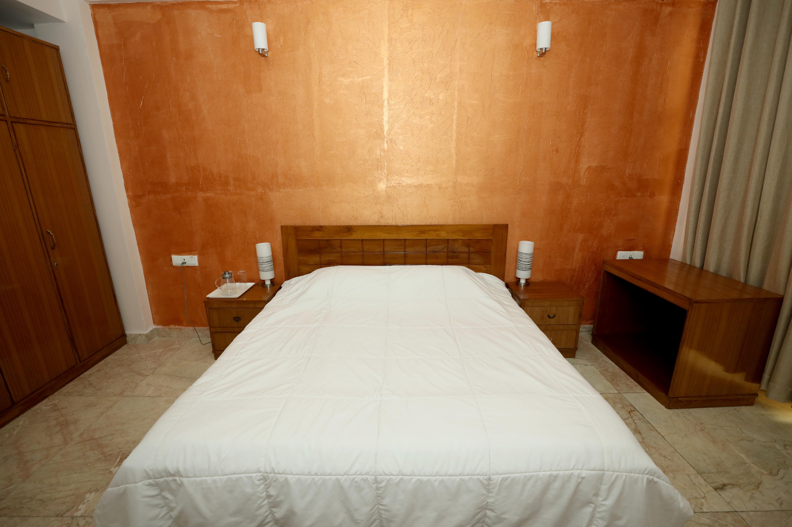 Comfortable private guest room at Patanjali Wellness with a double bed and essential amenities